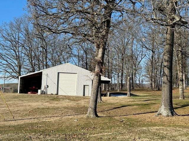 view of outdoor structure with a garage and a lawn