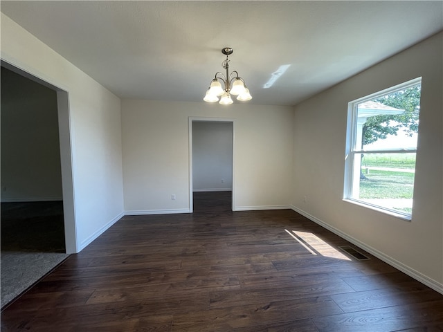 unfurnished room featuring dark wood-type flooring and a chandelier