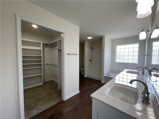 bathroom with independent shower and bath, a notable chandelier, vanity, and wood-type flooring