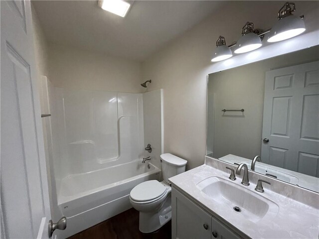 full bathroom with toilet, vanity, hardwood / wood-style flooring, and washtub / shower combination