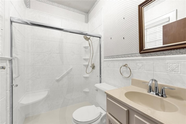 bathroom with vanity, toilet, tile walls, and a shower stall