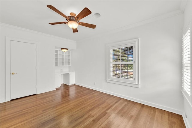 unfurnished bedroom with crown molding, multiple windows, and wood finished floors