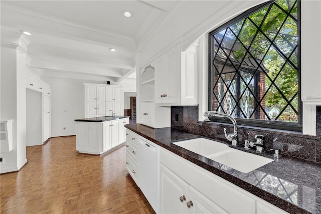 kitchen with dishwasher, decorative backsplash, plenty of natural light, white cabinets, and a sink