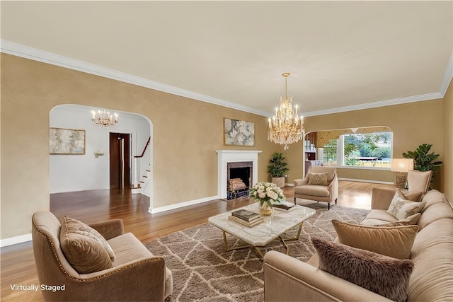 living area featuring arched walkways, a chandelier, a high end fireplace, and wood finished floors