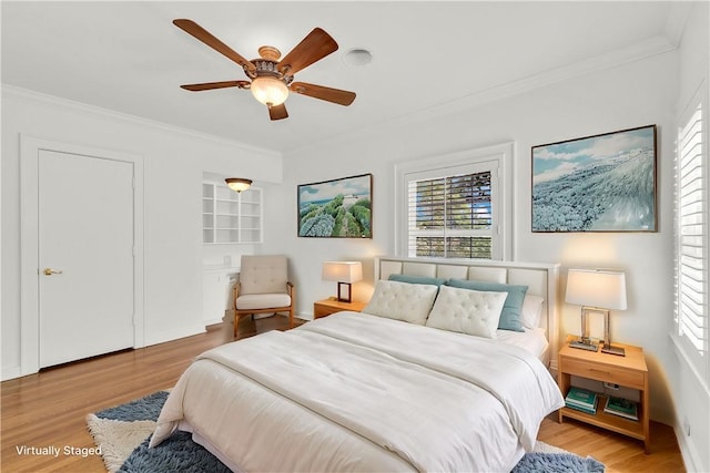 bedroom with crown molding, multiple windows, and wood finished floors