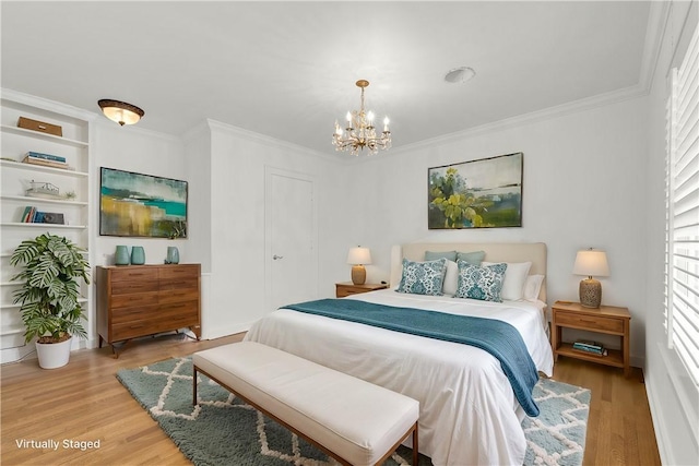 bedroom featuring a chandelier, crown molding, and light wood finished floors