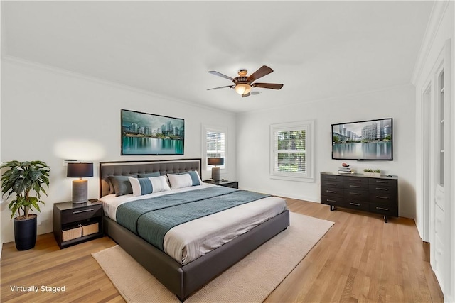 bedroom with crown molding, light wood-style flooring, and a ceiling fan