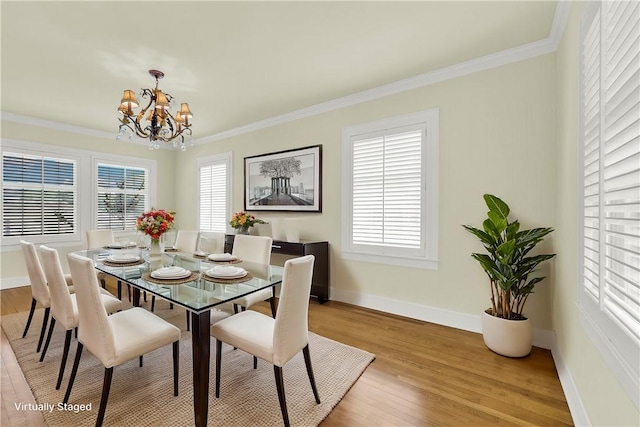 dining area with an inviting chandelier, baseboards, light wood finished floors, and ornamental molding