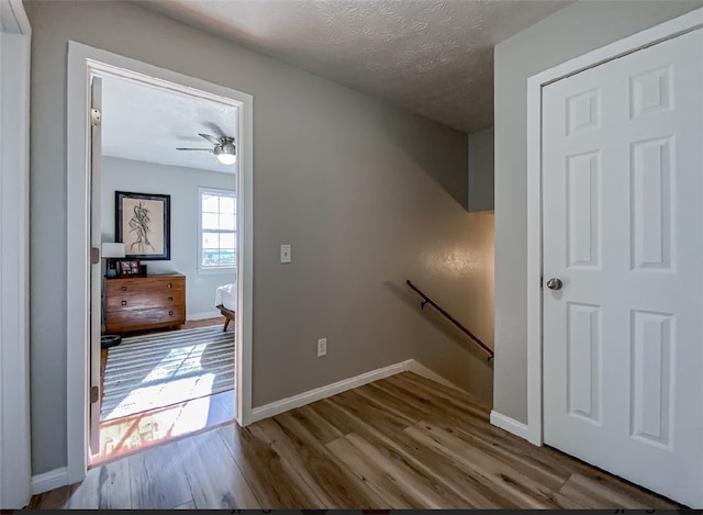 hall featuring a textured ceiling and hardwood / wood-style floors