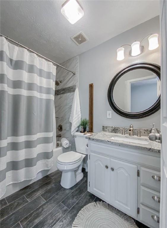 42 County Road 640, Green Forest, AR 72638 - bathroom with vanity, shower / tub combo, toilet, a textured ceiling, and visible vents