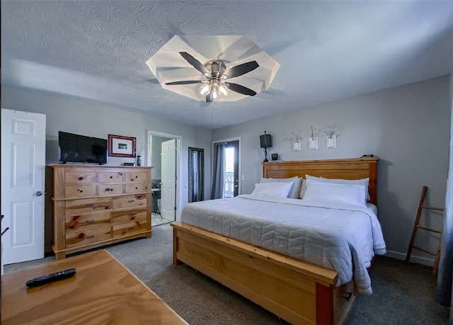 carpeted bedroom featuring ceiling fan and a textured ceiling