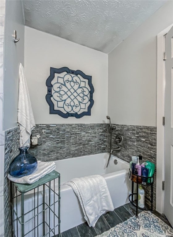 bathroom with a bath and a textured ceiling