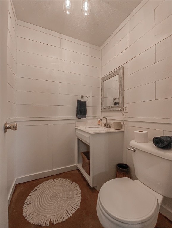 bathroom with vanity, toilet, and a textured ceiling