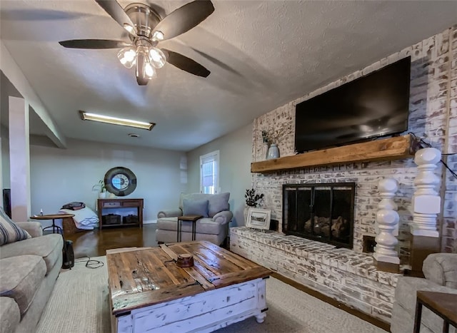 living room featuring a textured ceiling, a brick fireplace, and ceiling fan