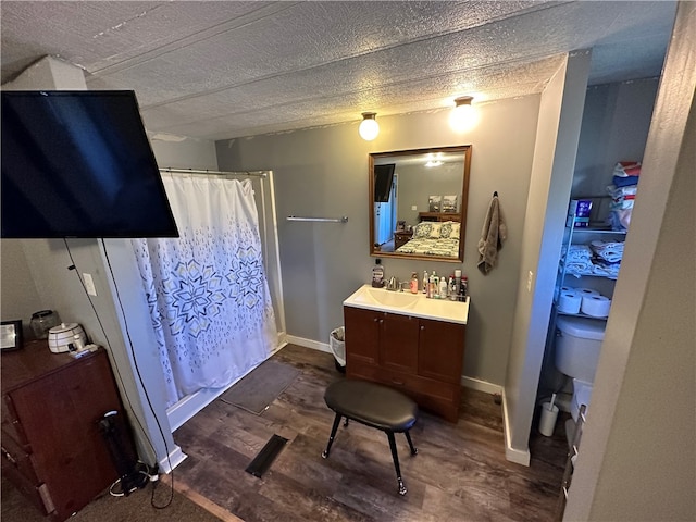 bathroom featuring walk in shower, vanity, a textured ceiling, and hardwood / wood-style floors