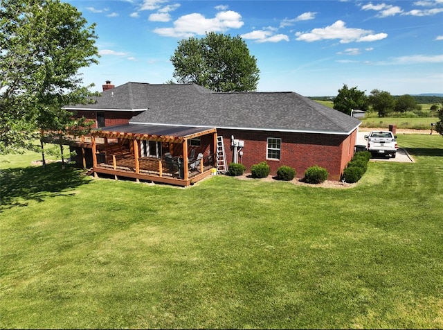 rear view of property with a wooden deck and a yard