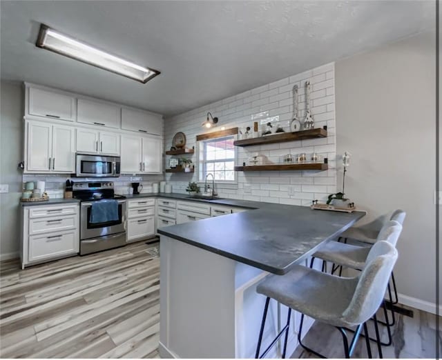 42 County Road 640, Green Forest, AR 72638 - kitchen with a sink, dark countertops, appliances with stainless steel finishes, and open shelves