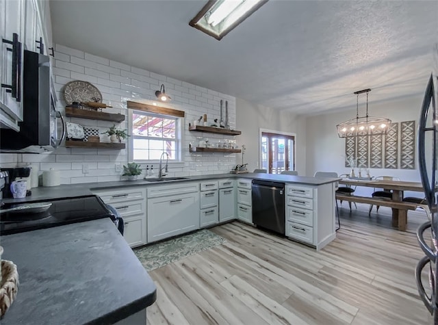 kitchen featuring appliances with stainless steel finishes, a wealth of natural light, kitchen peninsula, and sink