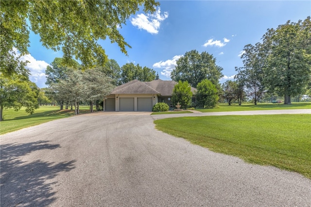 single story home with a garage and a front lawn