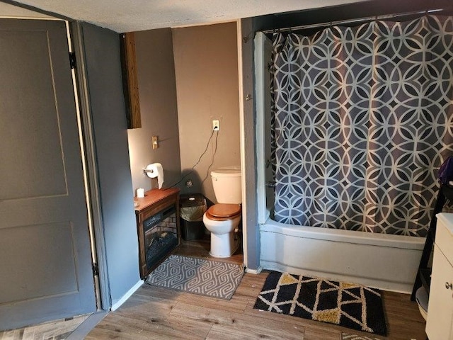 bathroom with wood-type flooring, toilet, and shower / tub combo with curtain