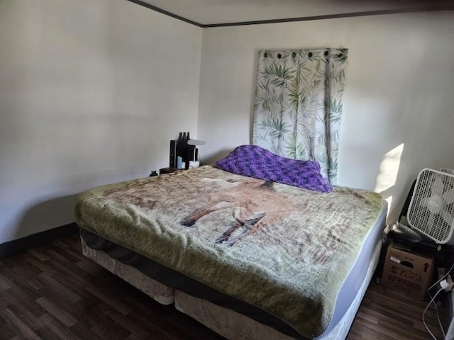 bedroom with dark hardwood / wood-style floors and crown molding