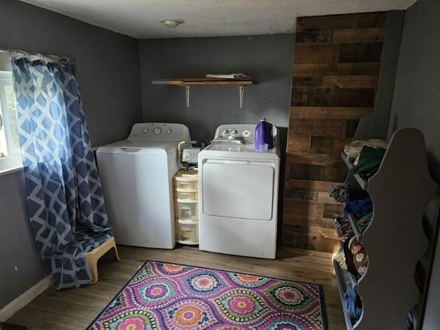 laundry room with washer and clothes dryer and hardwood / wood-style floors