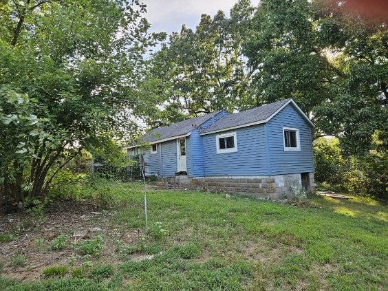 rear view of property featuring a yard