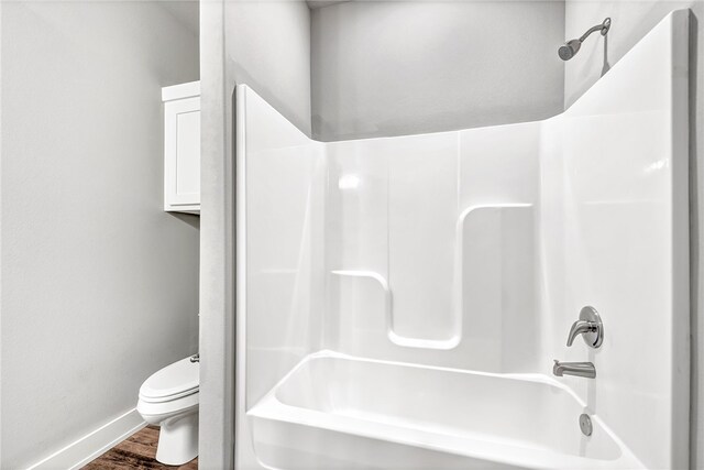 bathroom with toilet, shower / tub combination, and hardwood / wood-style floors