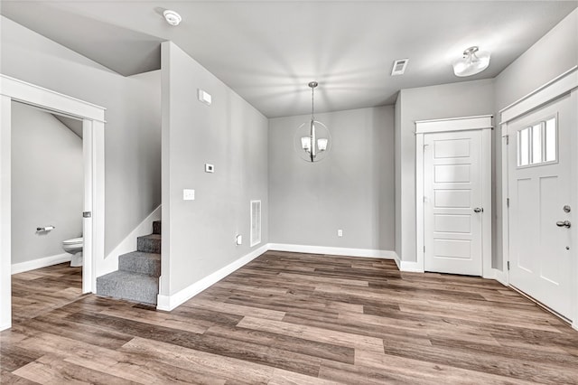 foyer entrance featuring dark hardwood / wood-style floors and an inviting chandelier