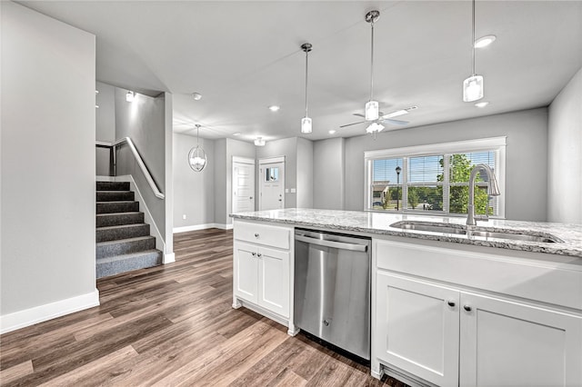 kitchen with dark hardwood / wood-style flooring, white cabinetry, light stone countertops, dishwasher, and sink