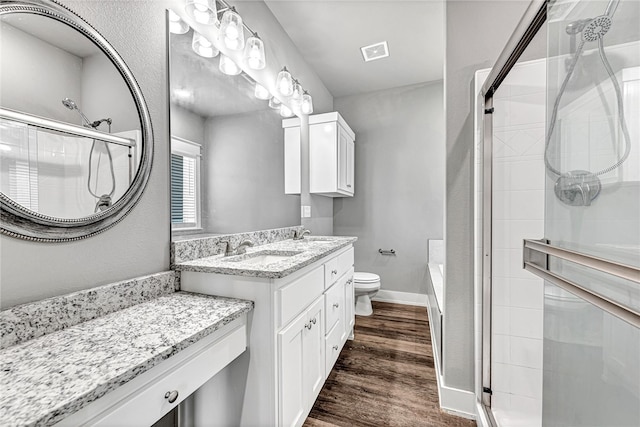 bathroom featuring vanity, toilet, hardwood / wood-style flooring, and an enclosed shower