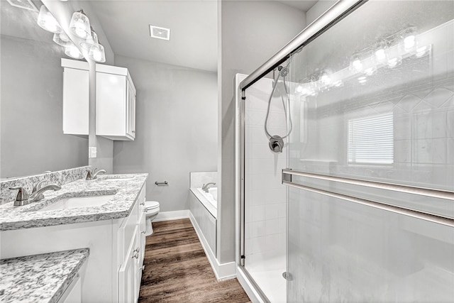 full bathroom with vanity, hardwood / wood-style floors, separate shower and tub, and toilet