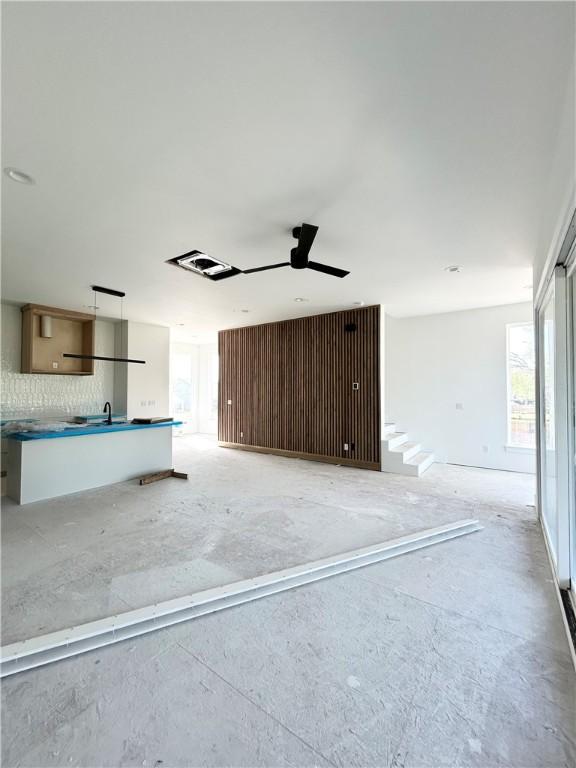 200 NW 9th St, Bentonville, AR 72712 - unfurnished living room with a ceiling fan, a sink, and plenty of natural light