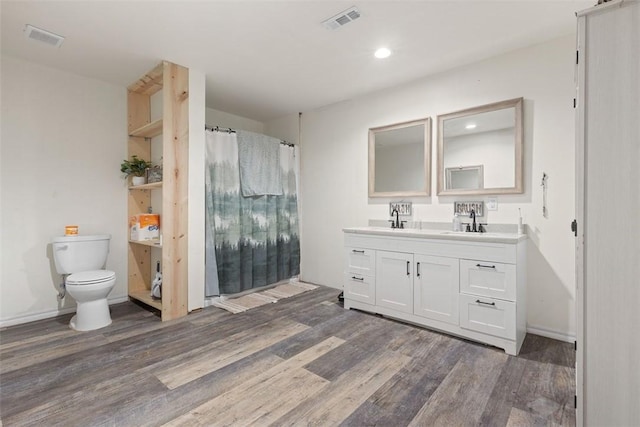 bathroom with wood-type flooring, vanity, and toilet