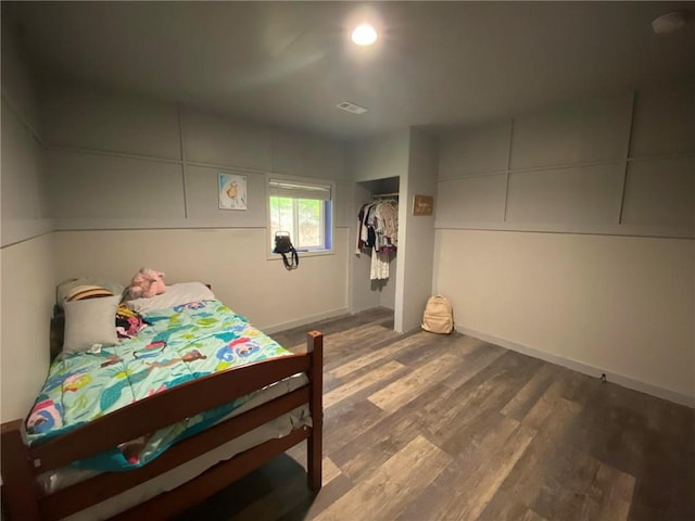 bedroom with hardwood / wood-style floors and a closet