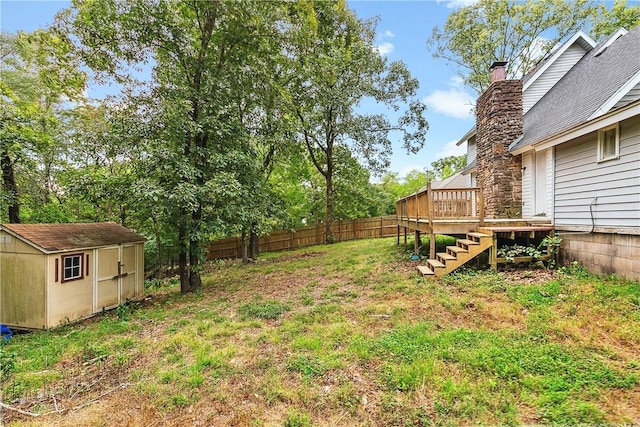 view of yard with a wooden deck and a storage unit