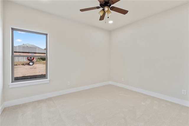 carpeted spare room featuring ceiling fan