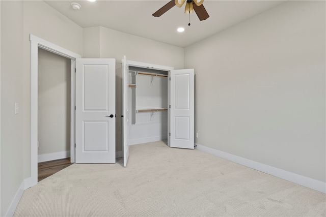 unfurnished bedroom with a closet, light colored carpet, and ceiling fan