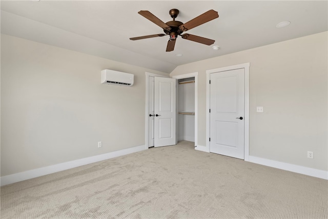 unfurnished bedroom featuring a wall unit AC, light colored carpet, and ceiling fan