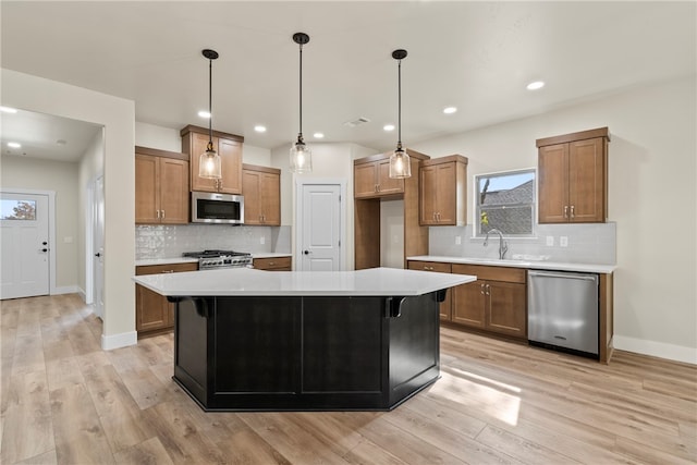 kitchen featuring appliances with stainless steel finishes, light hardwood / wood-style floors, and a center island