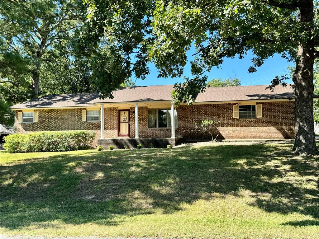 ranch-style house with brick siding and a front yard