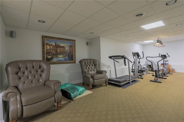 exercise room featuring a paneled ceiling and carpet flooring