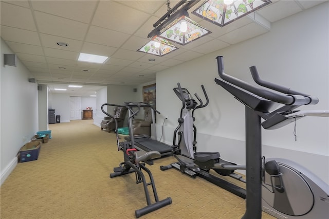 workout area featuring light colored carpet and a drop ceiling