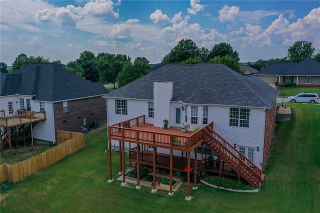 rear view of property with a lawn and a wooden deck