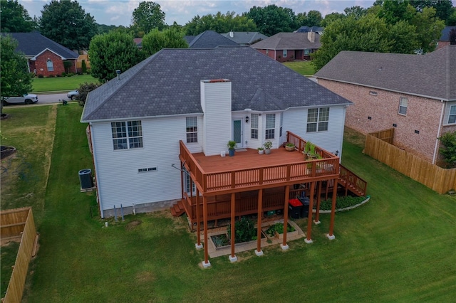 back of house featuring central air condition unit, a wooden deck, and a yard