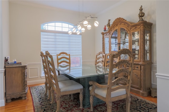 dining space featuring light hardwood / wood-style flooring and crown molding