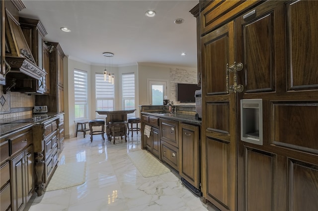 kitchen featuring hanging light fixtures, decorative backsplash, dark brown cabinets, and crown molding