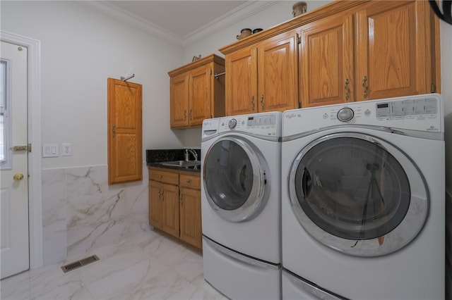 clothes washing area with sink, cabinets, independent washer and dryer, and crown molding