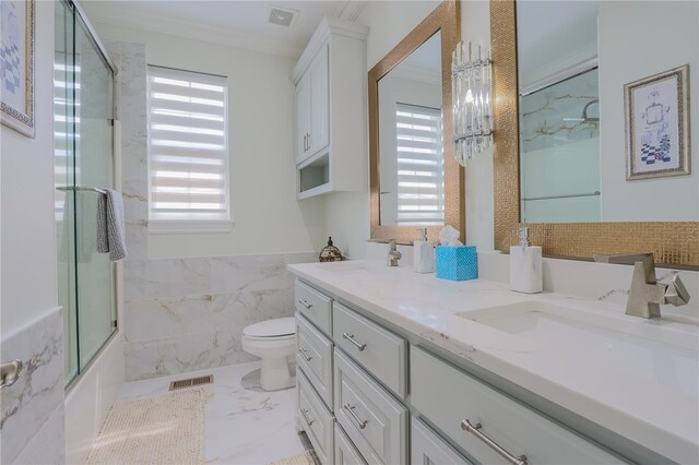 bathroom with toilet, vanity, and a healthy amount of sunlight