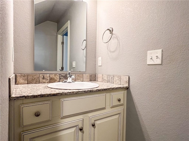 bathroom with vanity and a textured wall